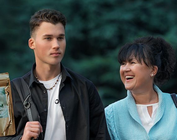 from left to right, kratom, son and mother smiling with trees behind them